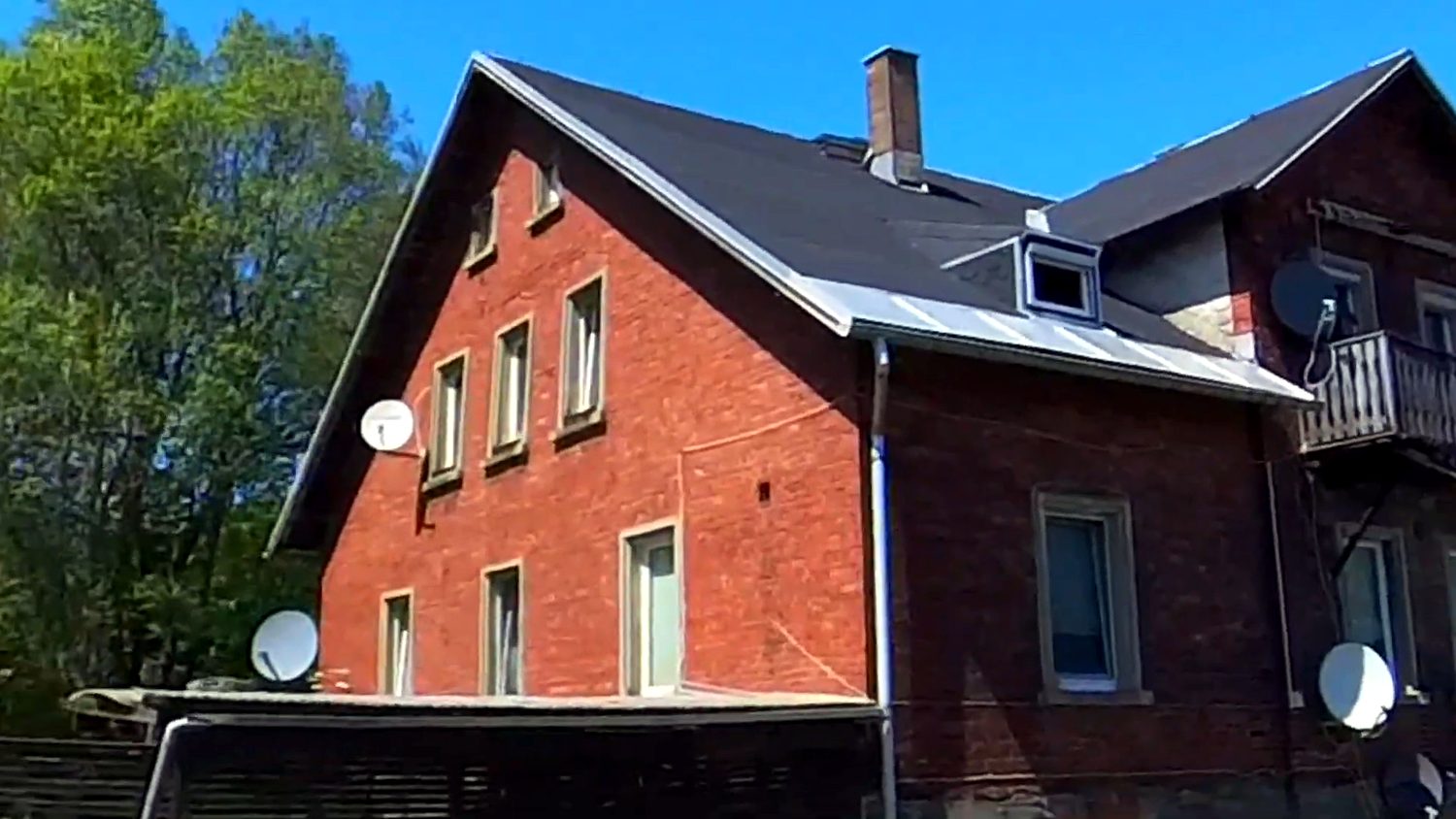 Giebelansicht des Backsteinhauses im Sommer